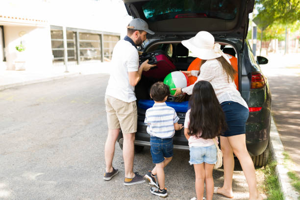 famiglia che si prepara a viaggiare in auto in un luogo di vacanza - car rear view behind car trunk foto e immagini stock