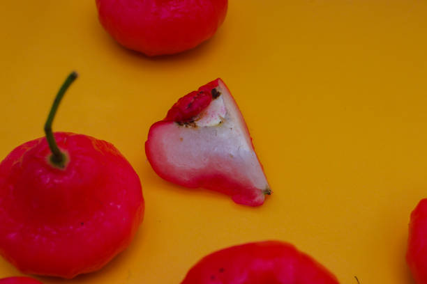istock Freshly rose apple fruit isolated on orange background. Also known as jambu air Merah (Syzygium aqueum), jambu Semarang (Syzygium samarangense), Jambu Bol, or Malay Apple (Syzygium malaccense) 1323930707