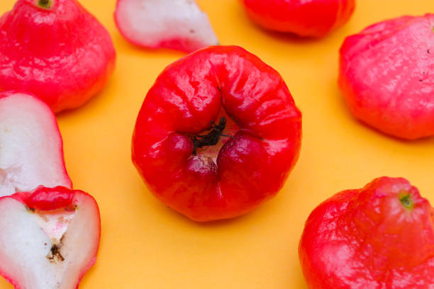 istock Freshly rose apple fruit isolated on orange background. Also known as jambu air Merah (Syzygium aqueum), jambu Semarang (Syzygium samarangense), Jambu Bol, or Malay Apple (Syzygium malaccense) 1323931056