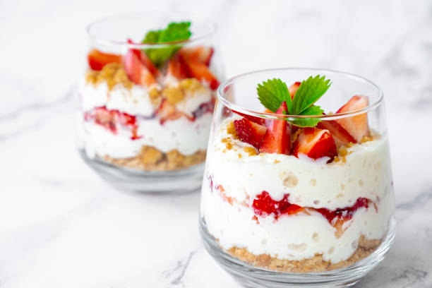 Strawberry trifle Strawberry dessert with cream cheese or yogurt, granola and fresh strawberry in glass on marble background. Recipe of simple healthy homemade organic dessert, cheesecake, mousse or berry trifle. tiramisu glass stock pictures, royalty-free photos & images