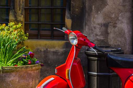 Red scooter parked in a rustic lane in Colmar France