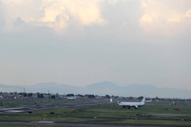 istock Airplane taking off or landing on runway with blue sky between clouds and mountains 1323939466