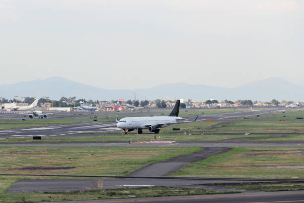 istock Airplane taking off or landing on runway with blue sky between clouds and mountains 1323939980