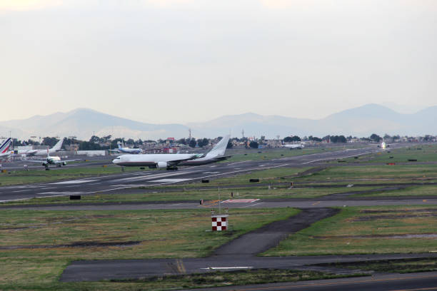 istock Airplane taking off or landing on runway with blue sky between clouds and mountains 1323939987