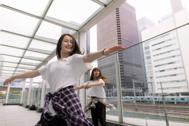 istock Young female dancers dancing in city 1323944251