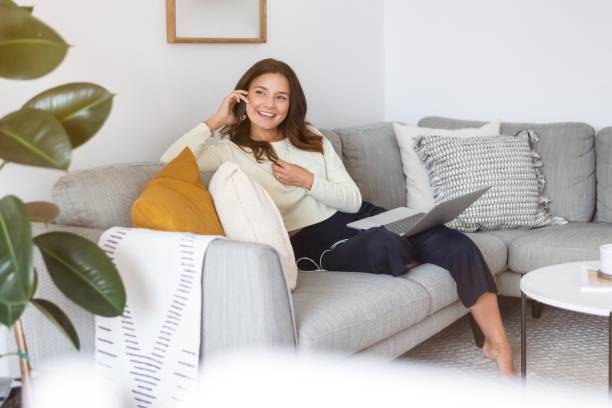 istock Millennial woman talking on phone while working remotely from home 1323946619