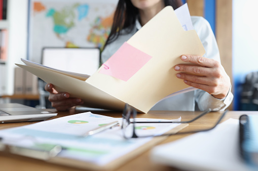 Woman is studying financial business documents at her desk