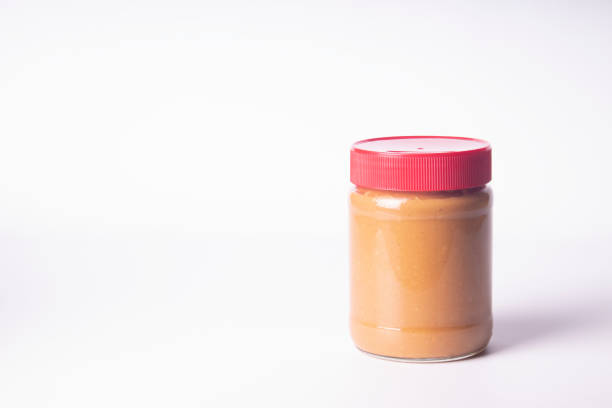 istock Peanut butter in a jar on a white background, horizontal orientation with space for text. 1323949762