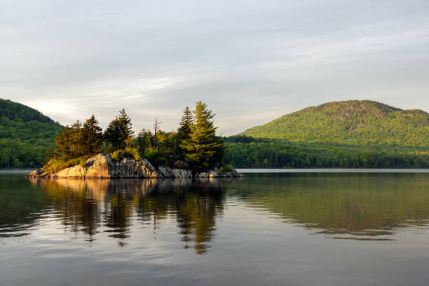View of Lac Stukely during sunset at Parc National du Mont-Orford, Quebec, Canada. There is a little island on the lake.