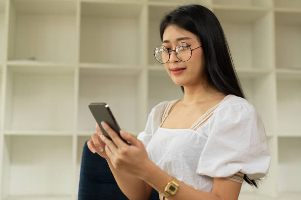 istock Portrait of female with eyeglasses using smartphone while sitting in workplace 1323968791