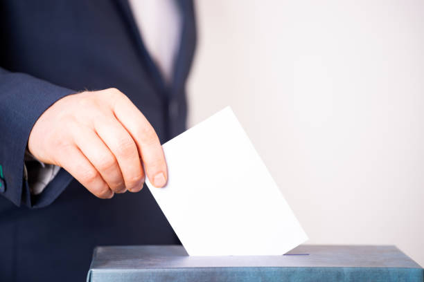 istock Voter Putting Ballot Into Voting box. 1323975689