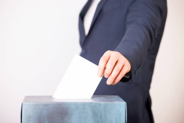 istock Voter Putting Ballot Into Voting box. 1323975721
