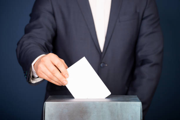 istock Voter Putting Ballot Into Voting box. 1323975749