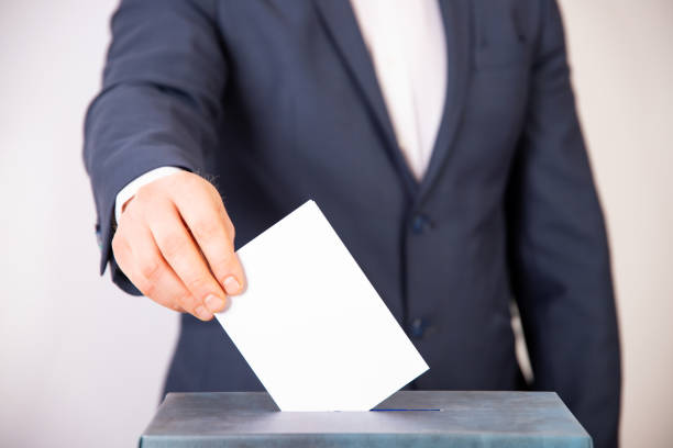 istock Voter Putting Ballot Into Voting box. 1323975840