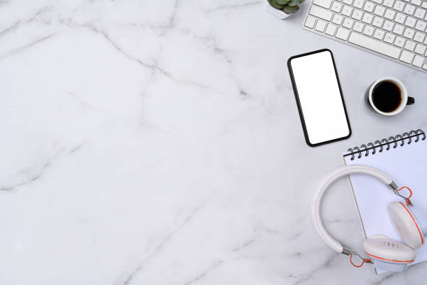 istock Top view mobile phone, headphone, notebook and keyboard on marble background. 1323975853