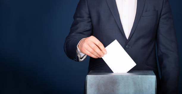 istock Voter Putting Ballot Into Voting box. 1323976070