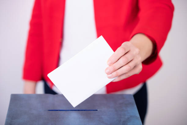 istock Voter Putting Ballot Into Voting box. 1323976095