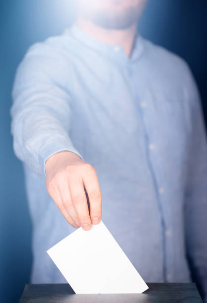 istock Voter Putting Ballot Into Voting box. 1323976609