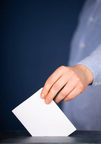 istock Voter Putting Ballot Into Voting box. 1323976622