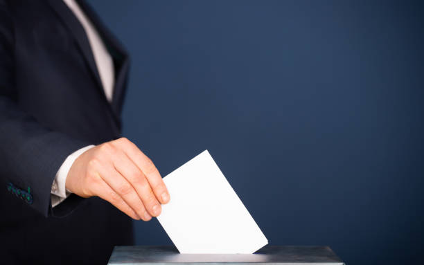 istock Voter Putting Ballot Into Voting box. 1323976730