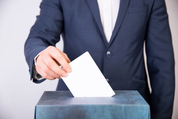 istock Voter Putting Ballot Into Voting box. 1323976794