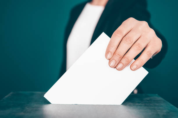 istock Voter Putting Ballot Into Voting box. 1323976810