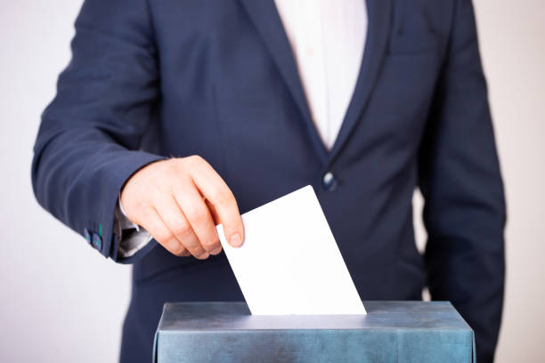 istock Voter Putting Ballot Into Voting box. 1323976876