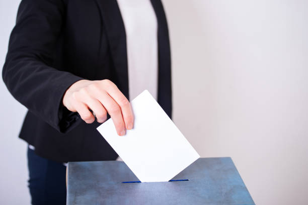 istock Voter Putting Ballot Into Voting box. 1323976973