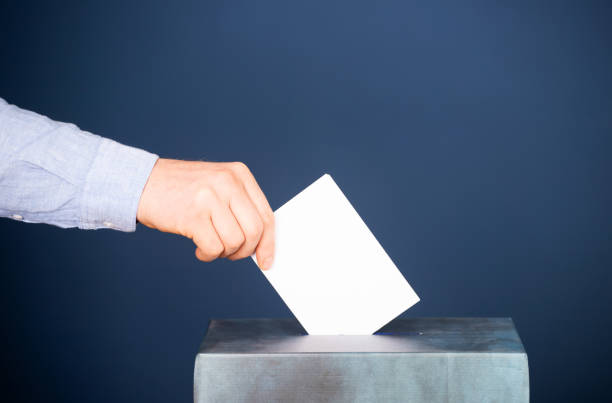 istock Voter Putting Ballot Into Voting box. 1323976996