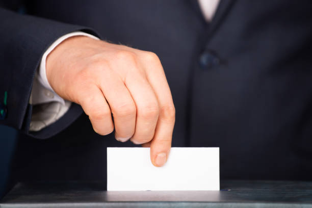 istock Voter Putting Ballot Into Voting box. 1323977025