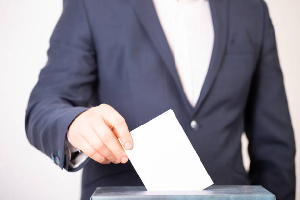 istock Voter Putting Ballot Into Voting box. 1323977039