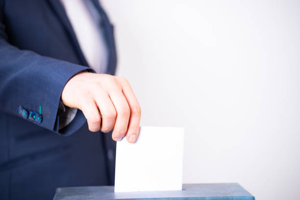 istock Voter Putting Ballot Into Voting box. 1323977613