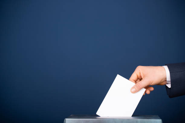 istock Voter Putting Ballot Into Voting box. 1323977648