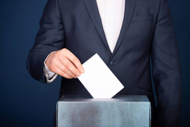 istock Voter Putting Ballot Into Voting box. 1323977681
