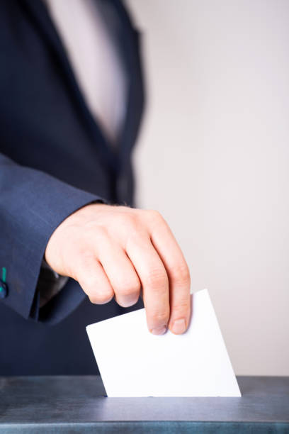 istock Voter Putting Ballot Into Voting box. 1323977705
