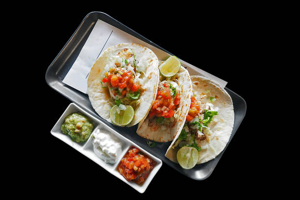 Mexican dish - mixed vegetables tacos serve on black plate dish isolated on black background with clipping path