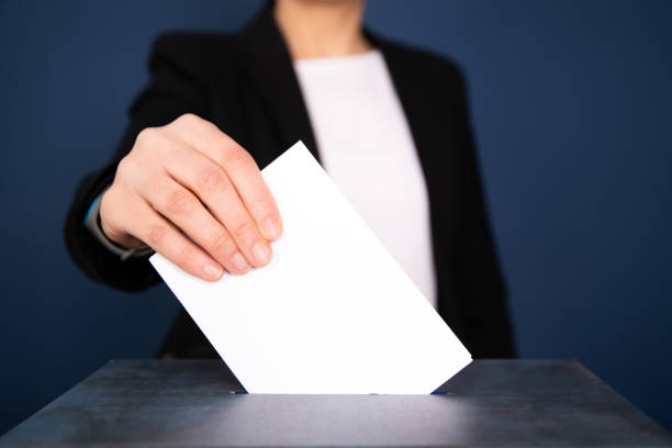 istock Voter Putting Ballot Into Voting box. 1323979557