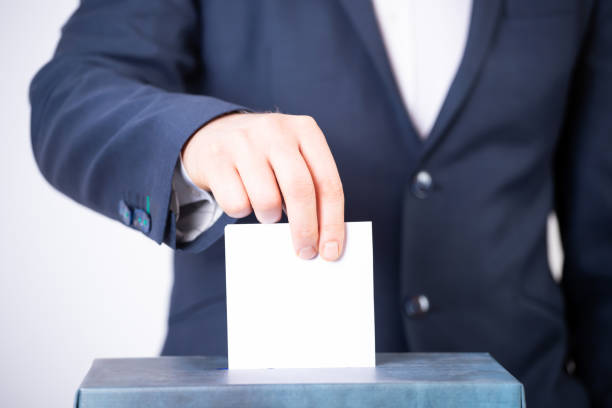 istock Voter Putting Ballot Into Voting box. 1323979606