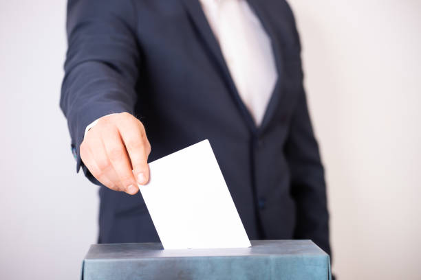 istock Voter Putting Ballot Into Voting box. 1323979822