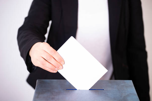 istock Voter Putting Ballot Into Voting box. 1323979882