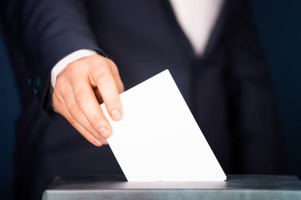 istock Voter Putting Ballot Into Voting box. 1323979904