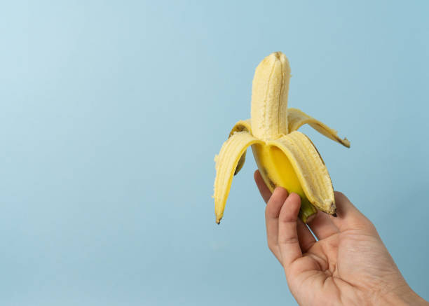 istock Hand a man holds banana with a copy space. 1323986089