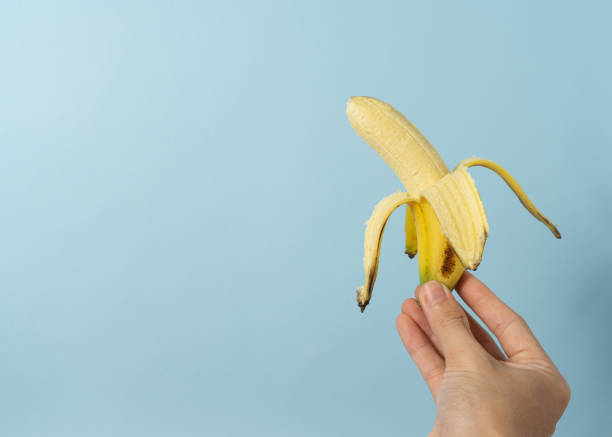 istock Hand a man holds banana with a copy space. 1323986307