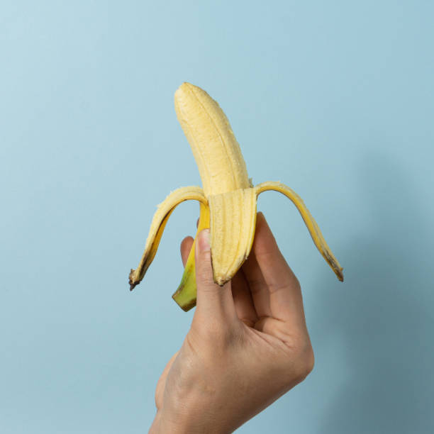 istock Hand a man holds a banana. 1323986324