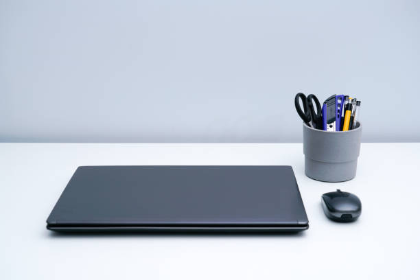 Laptop and pen holder on white desktop