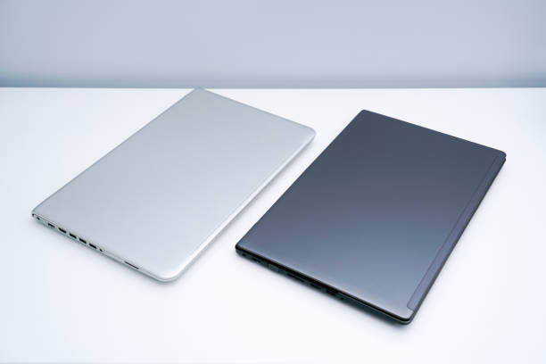 istock Dark gray and silver gray laptops placed on white desks 1323989336