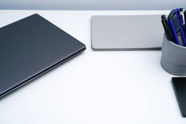 istock Dark gray laptop on white desk 1323989388