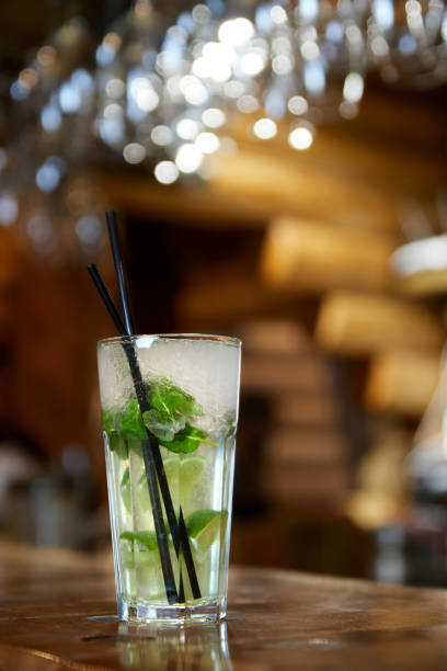 istock Mojito cocktail with straw on the bar. Close-up, selective focus. 1323989630