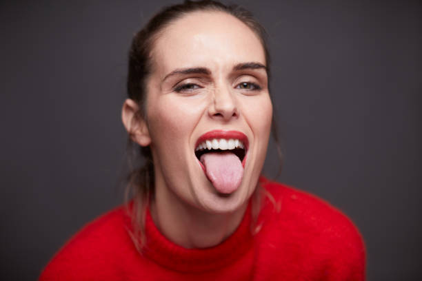 eine schöne frau, die ein gesicht macht. - zunge herausstrecken stock-fotos und bilder