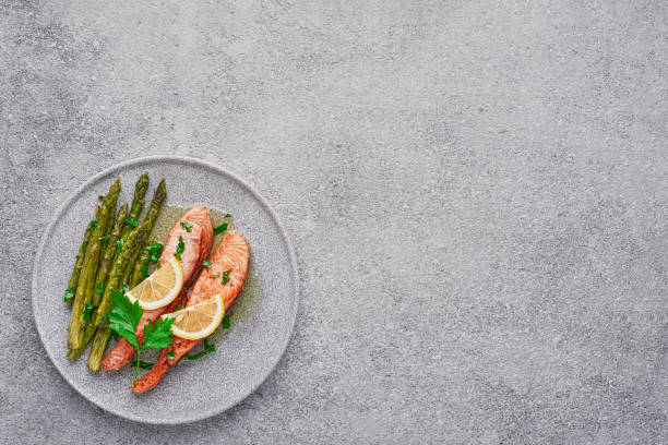 istock Cooked salmon fillet with asparagus in a plate with copy space top view 1323994894